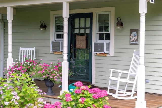 view of exterior entry featuring a porch and cooling unit