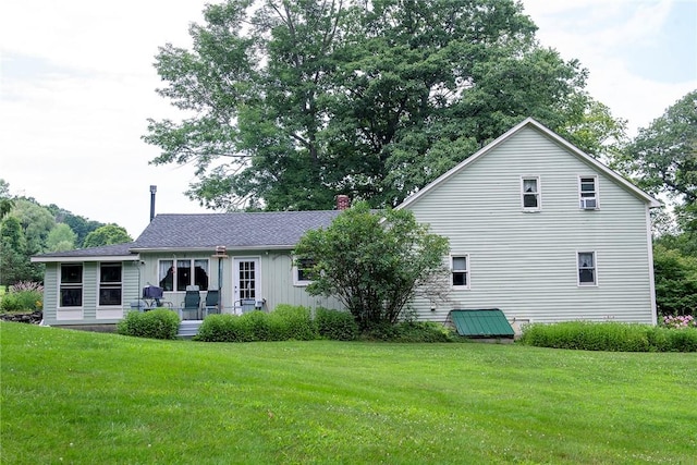 back of property featuring a lawn