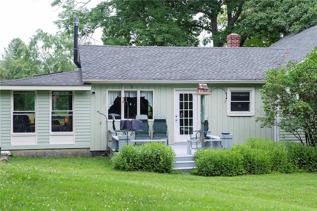 rear view of property featuring a porch and a yard