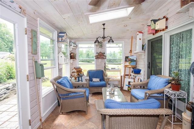 sunroom featuring wood ceiling, vaulted ceiling with skylight, and a healthy amount of sunlight