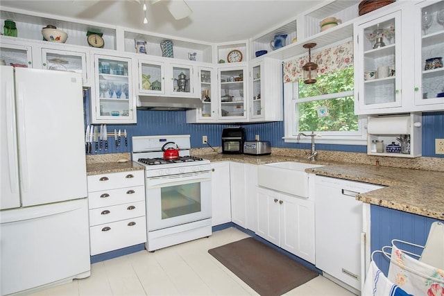 kitchen with white appliances, sink, decorative light fixtures, light stone counters, and white cabinetry