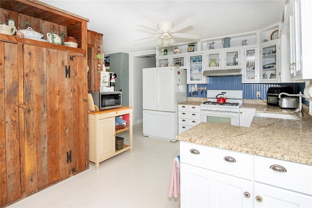 kitchen featuring ceiling fan, white cabinetry, light stone countertops, and white appliances