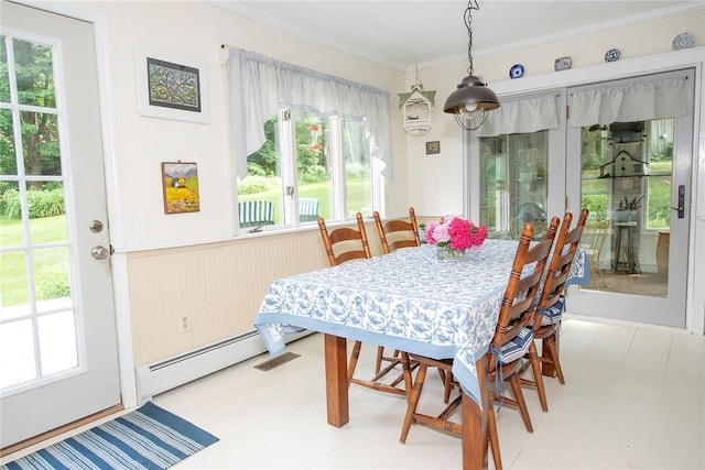 dining area featuring crown molding, a wealth of natural light, and a baseboard radiator