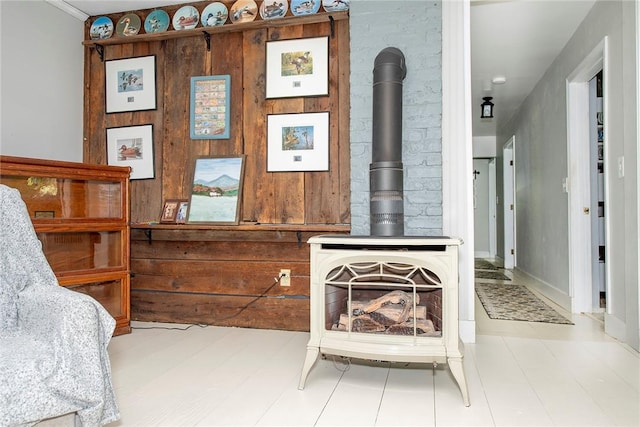 living room featuring a wood stove and wooden walls