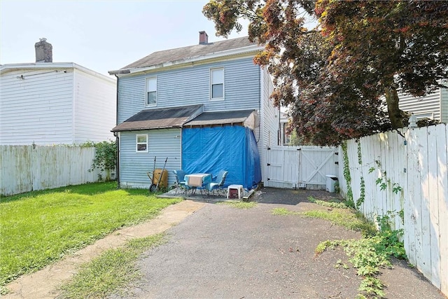 rear view of property with a lawn and a patio