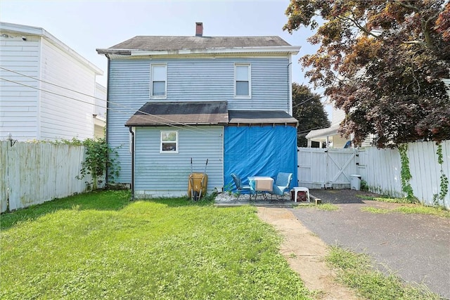 rear view of property featuring a yard