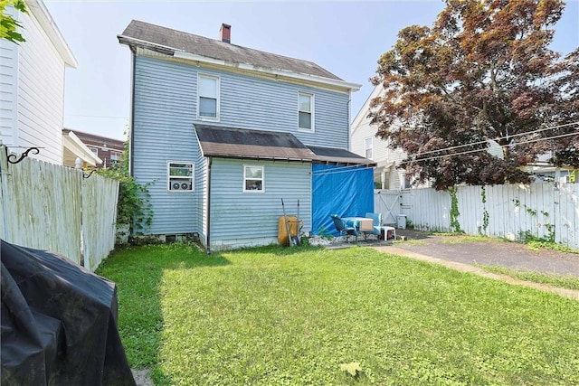 rear view of house featuring a lawn