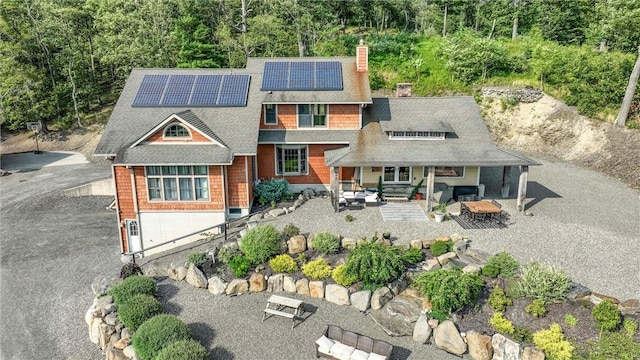 view of front of house with solar panels, a patio, and an outdoor living space