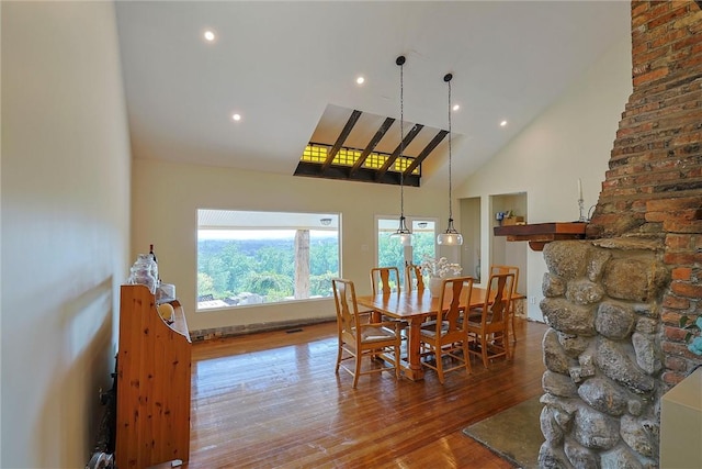 dining space featuring hardwood / wood-style floors and high vaulted ceiling