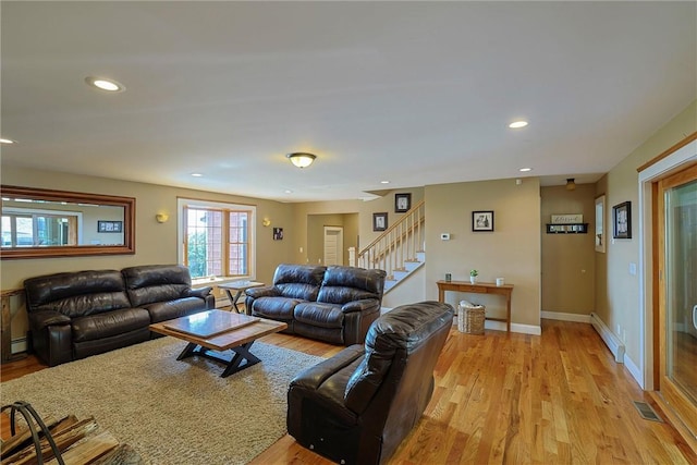 living room with light wood-type flooring and a baseboard radiator