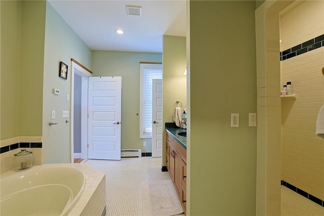 bathroom with tile patterned flooring, vanity, tiled tub, and a baseboard heating unit