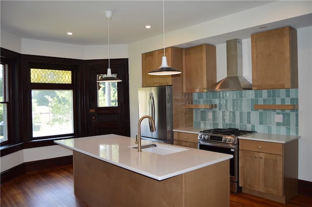 kitchen with sink, wall chimney exhaust hood, dark wood-type flooring, stainless steel appliances, and pendant lighting