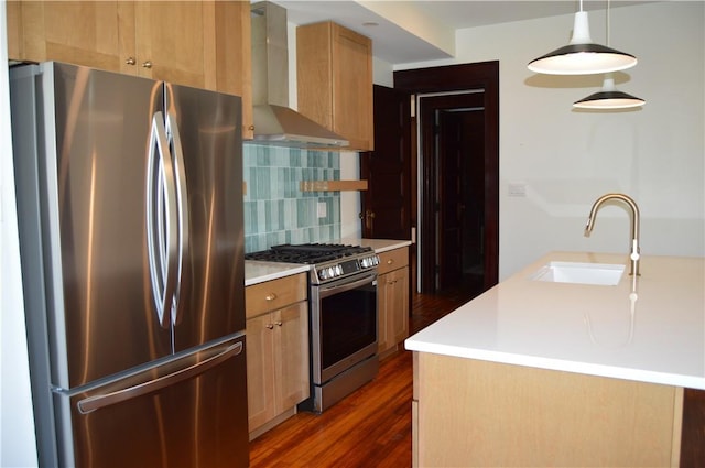 kitchen featuring pendant lighting, wall chimney range hood, sink, dark hardwood / wood-style flooring, and stainless steel appliances