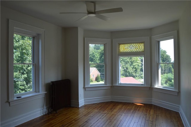 interior space featuring radiator heating unit, ceiling fan, and dark wood-type flooring