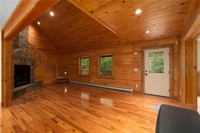 unfurnished living room featuring baseboard heating, wooden walls, light hardwood / wood-style flooring, and wooden ceiling