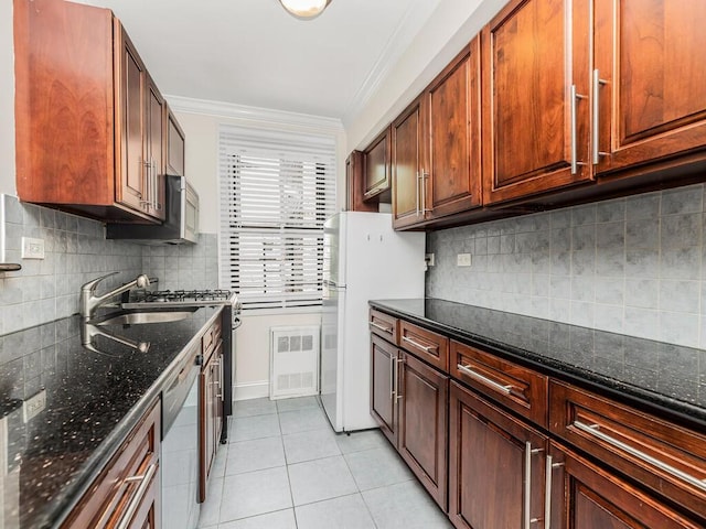 kitchen featuring dark stone counters, backsplash, crown molding, and stainless steel appliances