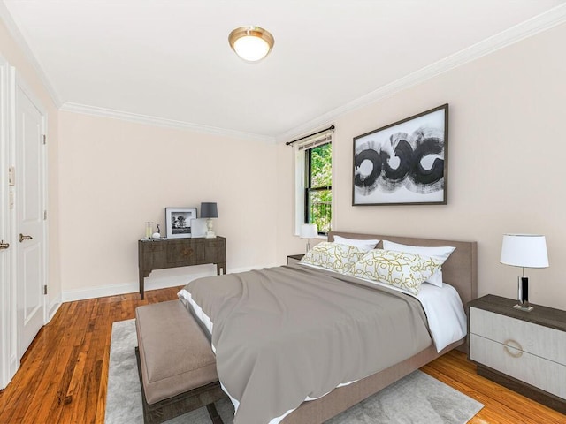 bedroom with hardwood / wood-style floors and ornamental molding