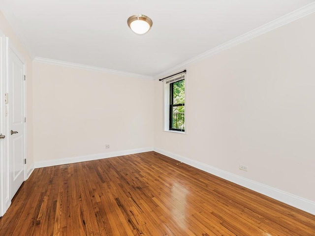 spare room with wood-type flooring and ornamental molding