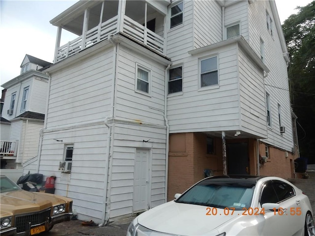 rear view of house with cooling unit and a balcony