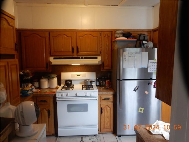 kitchen with stainless steel fridge and white gas range oven