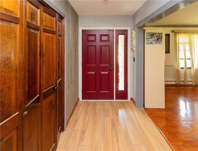 foyer entrance with light wood-type flooring and baseboard heating