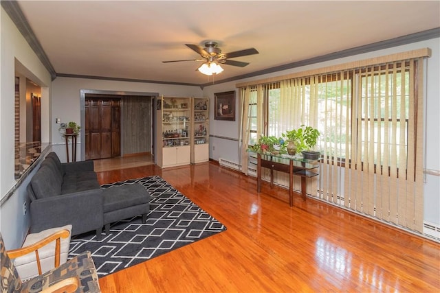 living room featuring ceiling fan, wood-type flooring, crown molding, and a baseboard radiator