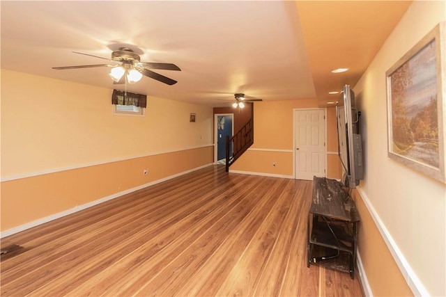 unfurnished living room with ceiling fan and hardwood / wood-style flooring