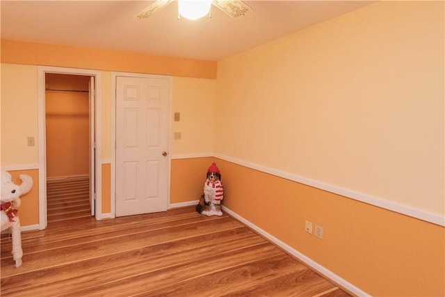 unfurnished bedroom featuring hardwood / wood-style floors and ceiling fan