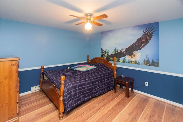 bedroom featuring hardwood / wood-style floors, ceiling fan, and baseboard heating