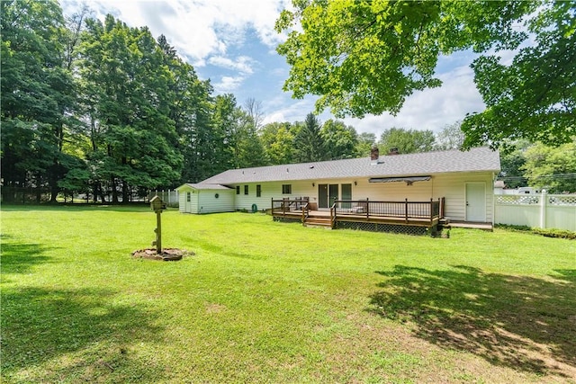 rear view of property with a lawn and a deck