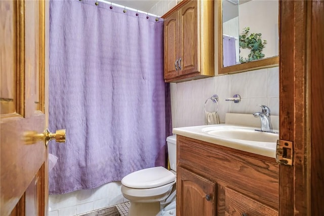 bathroom with vanity, tile patterned floors, toilet, tile walls, and walk in shower