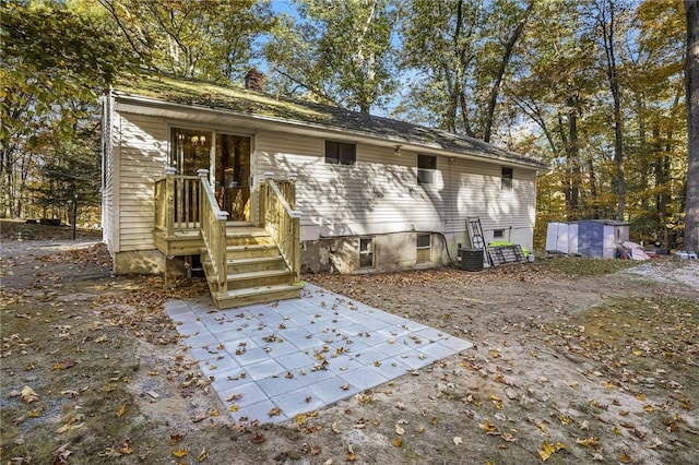 back of house with a patio area and a shed