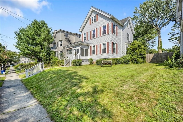 view of front of home featuring a sunroom and a front lawn