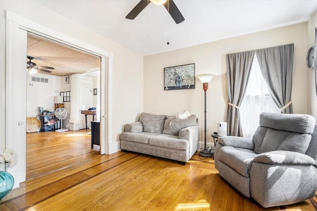 living room featuring hardwood / wood-style floors and ceiling fan