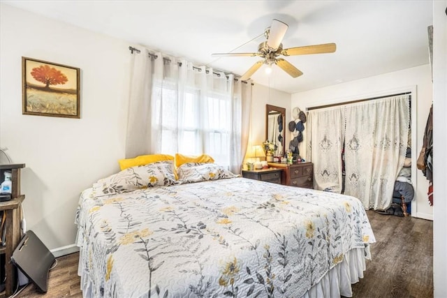 bedroom with dark hardwood / wood-style flooring and ceiling fan