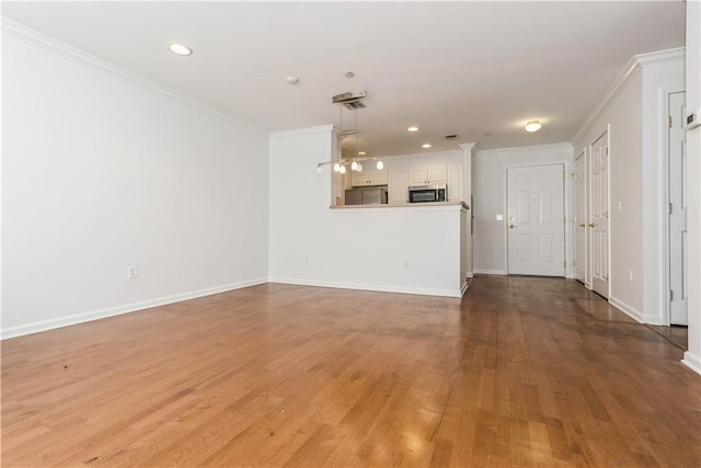 unfurnished living room featuring crown molding and wood-type flooring