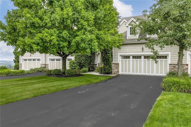 obstructed view of property featuring a front lawn and a garage