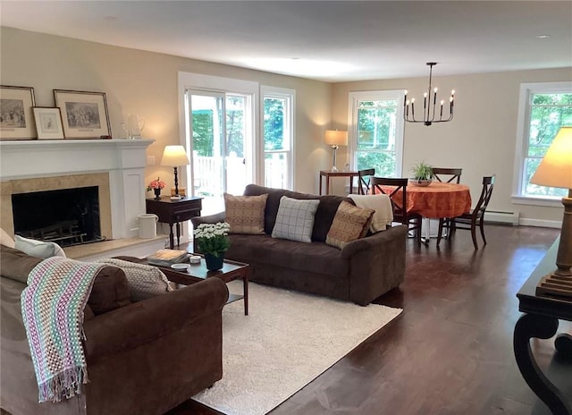 living room featuring dark wood-type flooring, a baseboard radiator, and an inviting chandelier