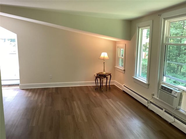 unfurnished room featuring a baseboard radiator, dark hardwood / wood-style floors, and lofted ceiling