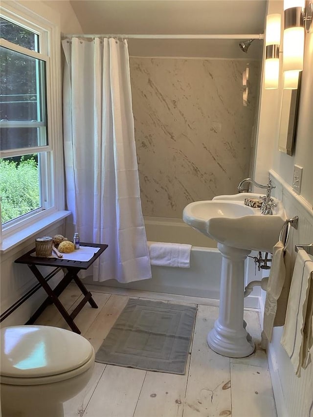 bathroom featuring shower / tub combo and toilet