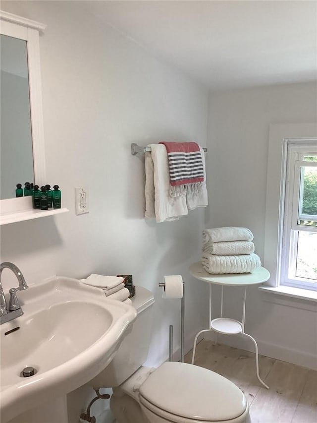 bathroom with hardwood / wood-style flooring, toilet, and sink