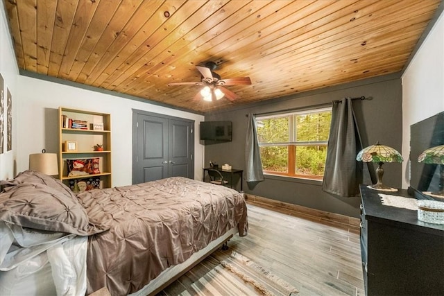 bedroom featuring ceiling fan, a closet, light hardwood / wood-style floors, and wooden ceiling