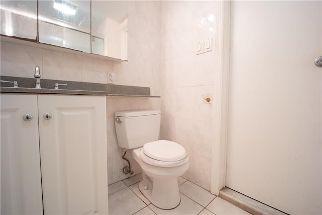 bathroom with tile patterned floors, vanity, tile walls, and toilet