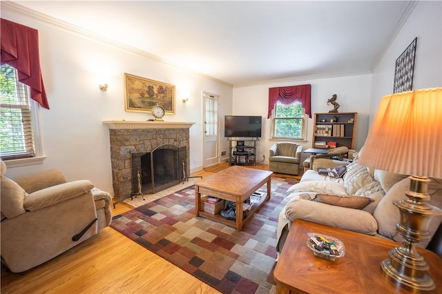 living room with a fireplace, hardwood / wood-style flooring, crown molding, and a healthy amount of sunlight