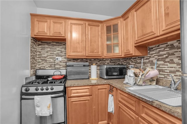 kitchen featuring decorative backsplash, stainless steel appliances, and light stone counters