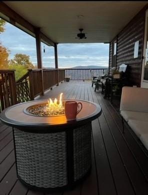 wooden deck with an outdoor fire pit and ceiling fan