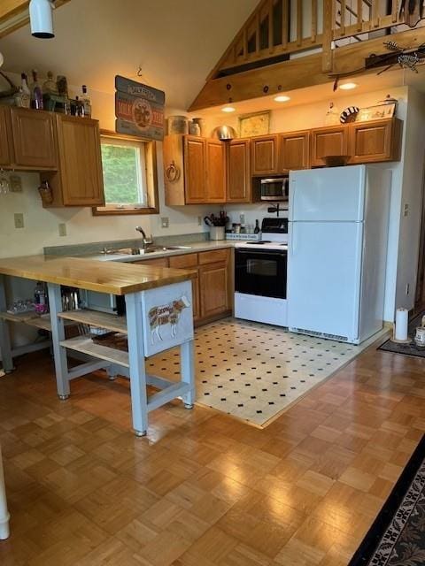 kitchen featuring sink, high vaulted ceiling, and white appliances