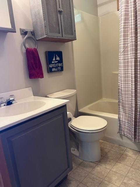 full bathroom with vanity, shower / bath combo, and toilet