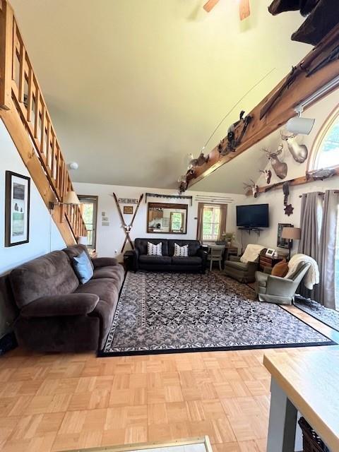 living room featuring ceiling fan, a wealth of natural light, and light parquet flooring