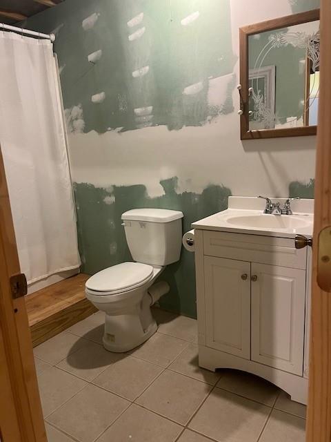 bathroom with tile patterned flooring, vanity, and toilet